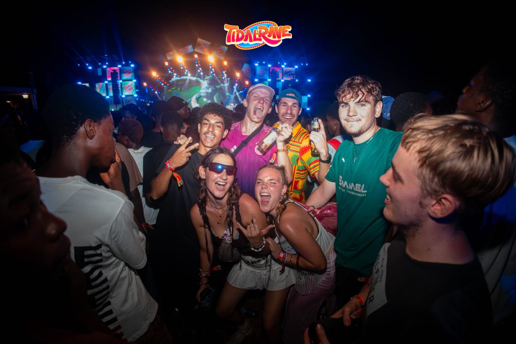 Festival-goers dancing together in the crowd at night