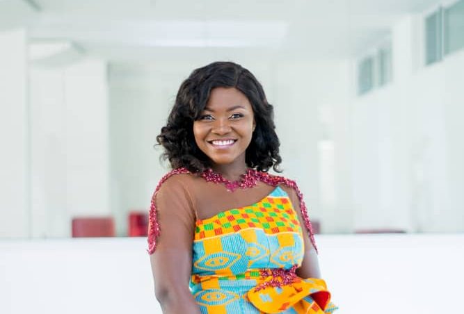 Portrait of a woman wearing a kente-patterned dress