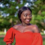 Portrait of a woman in a red off-shoulder top photographed outdoors