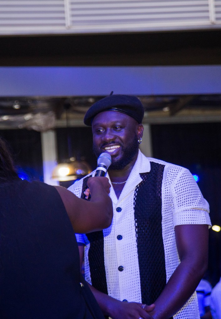 A performer singing into a microphone under stage lights