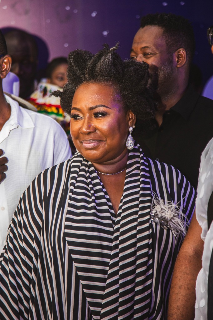 A guest in a black and white striped outfit smiling at the event