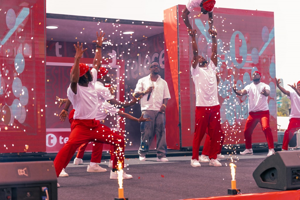 Dancers in red and white performing on stage amid sparks and confetti at the Telecel launch