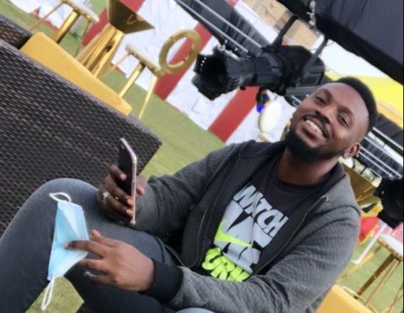 A creator seated outdoors holding up a phone to film