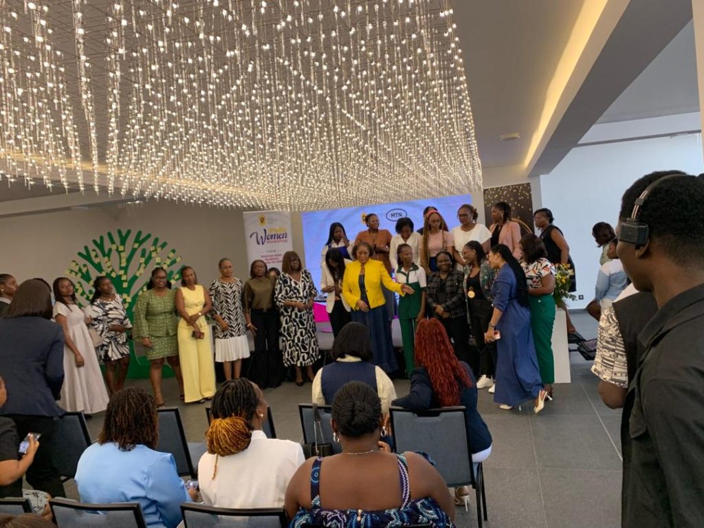 Guests posing together for a group photo at the front of the venue while a videographer films